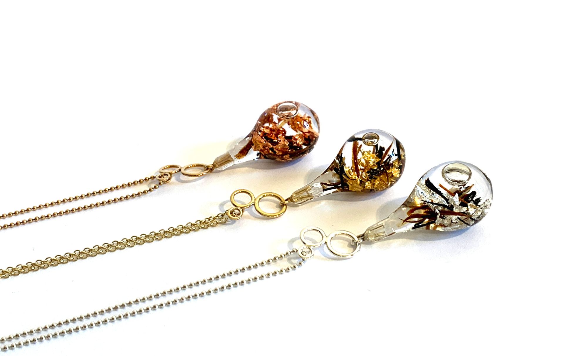 Three glass drop pendants on rose gold, gold and silver chains