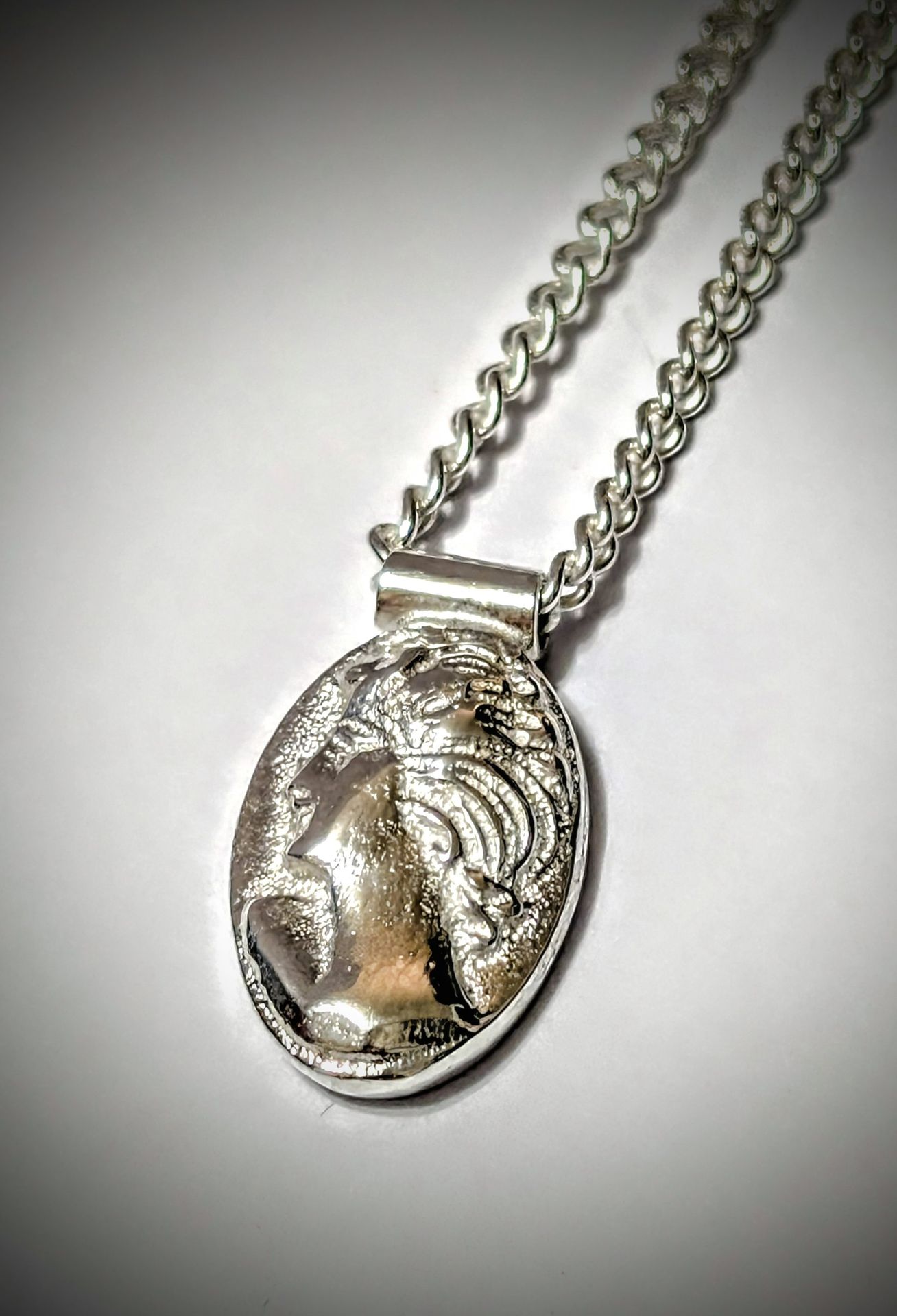 Silver cameo-inspired pendant on a curb chain