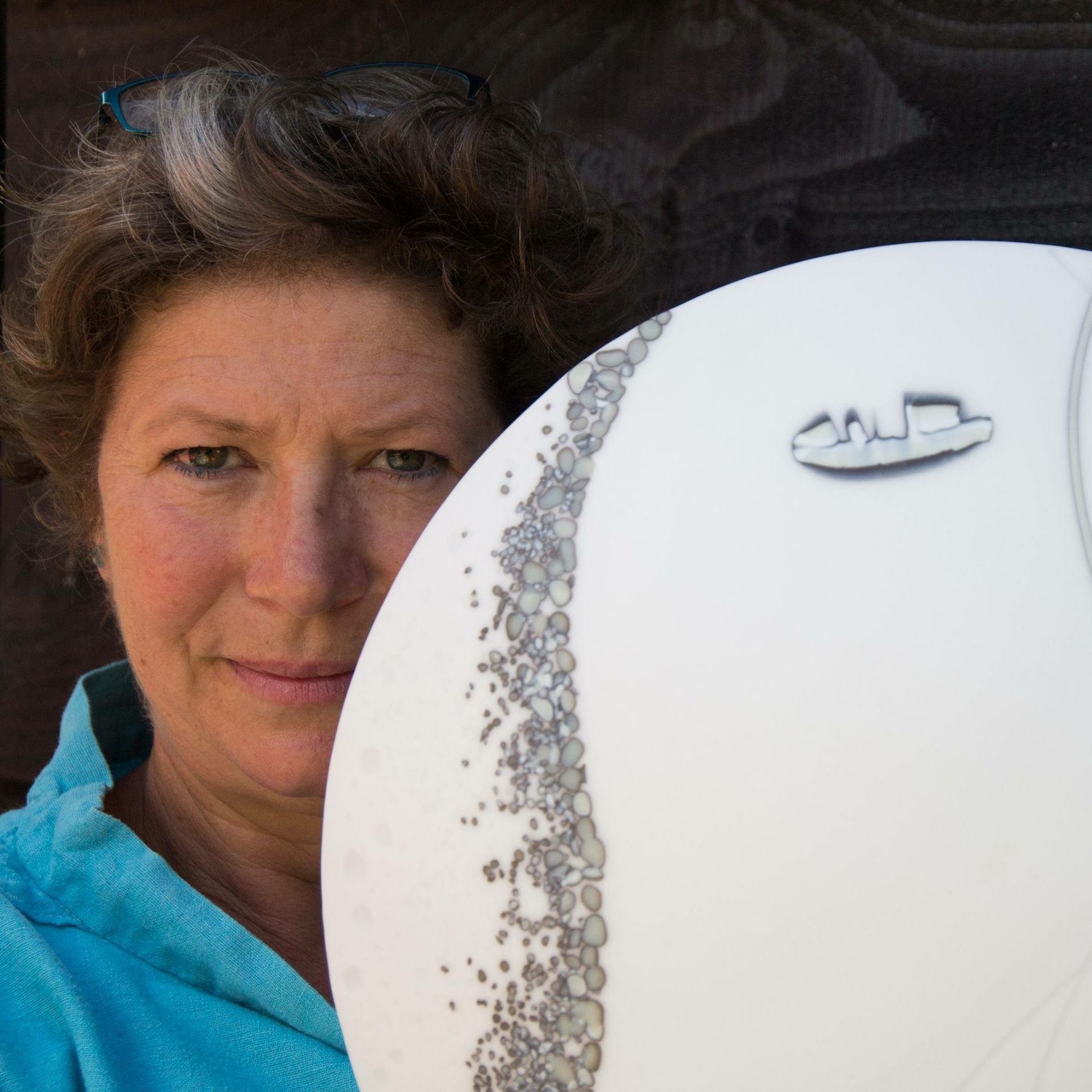 Sue Tinkler holding a white fused glass plate