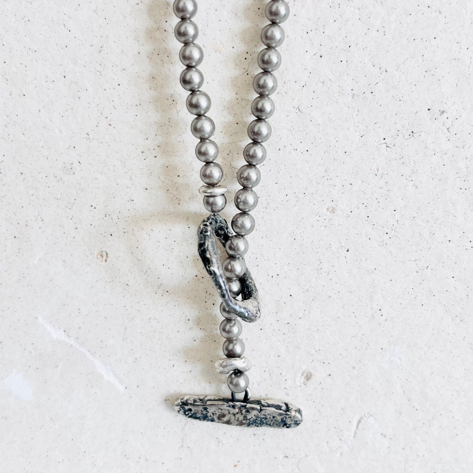 Grey pearl necklace with a textured oxidised silver ring and bar clasp