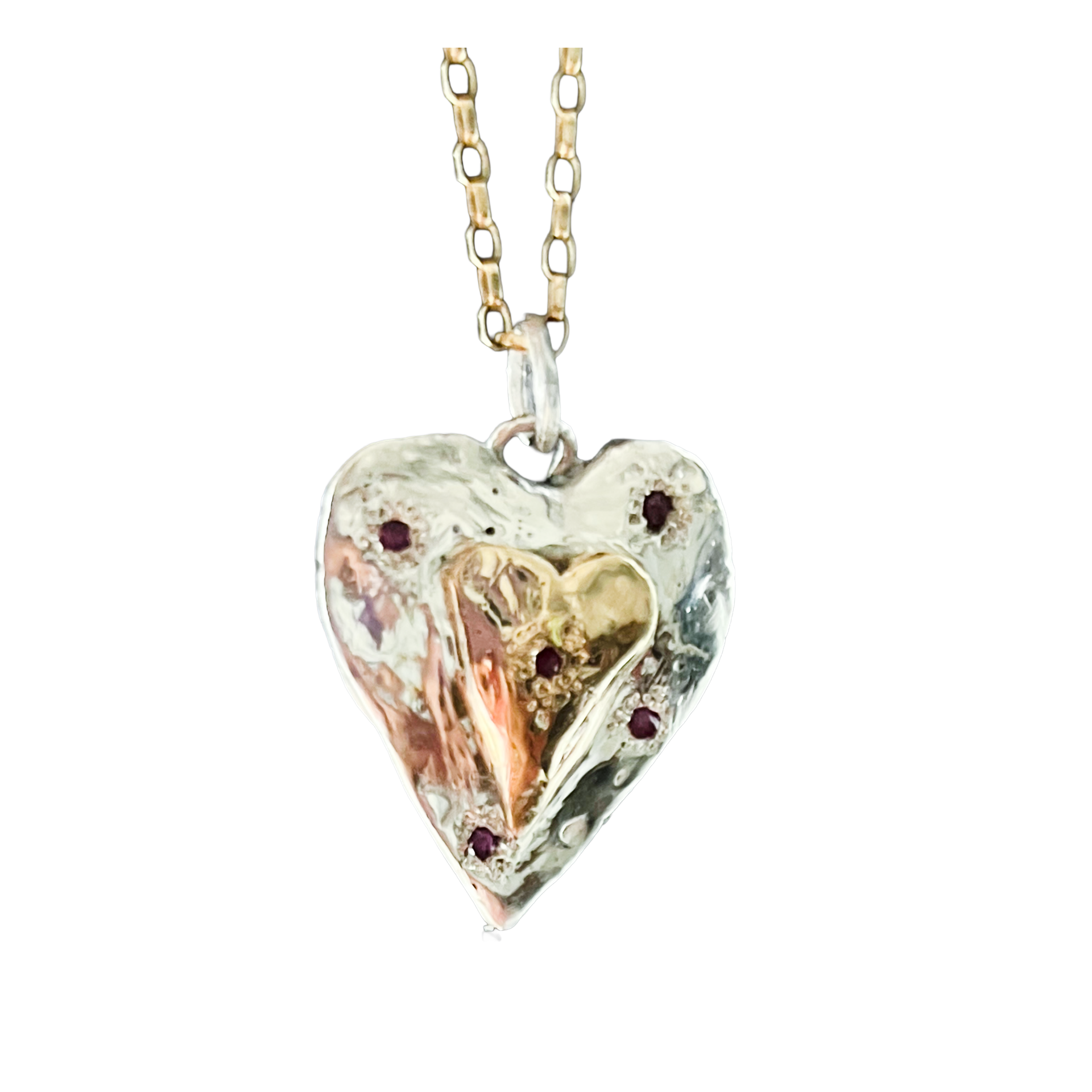 Silver heart pendant with a gold heart overlay and small red stones