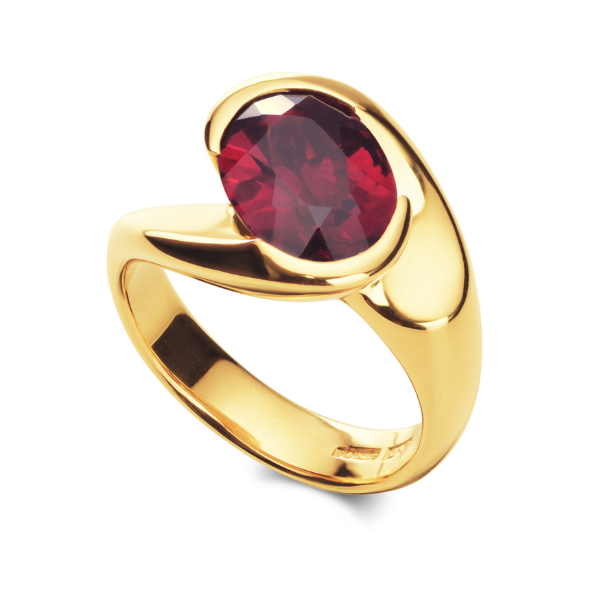 Gold ring set with an oval red gemstone