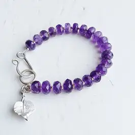 Faceted amethyst bead bracelet with a silver heart-leaf charm